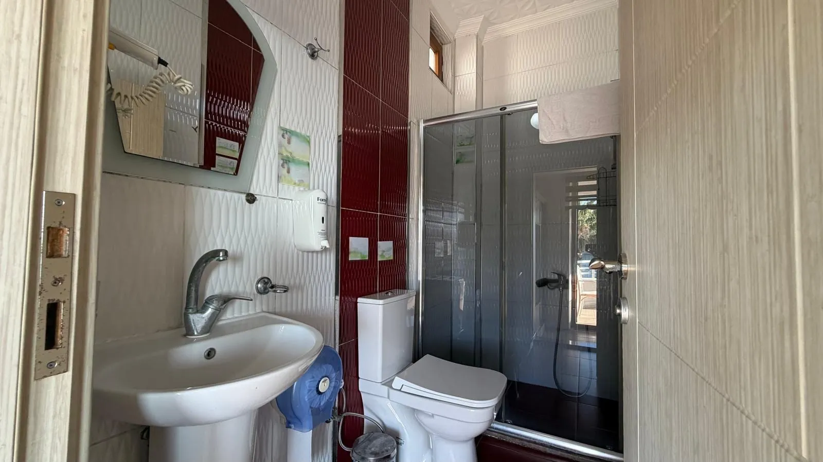 Aile odası banyosu: cam duşakabin, lavabo ve klozet