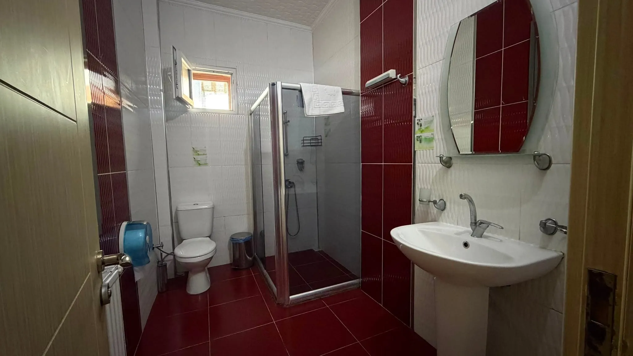 Deluxe oda banyosu: duşakabin, lavabo, klozet ve bordo zemin