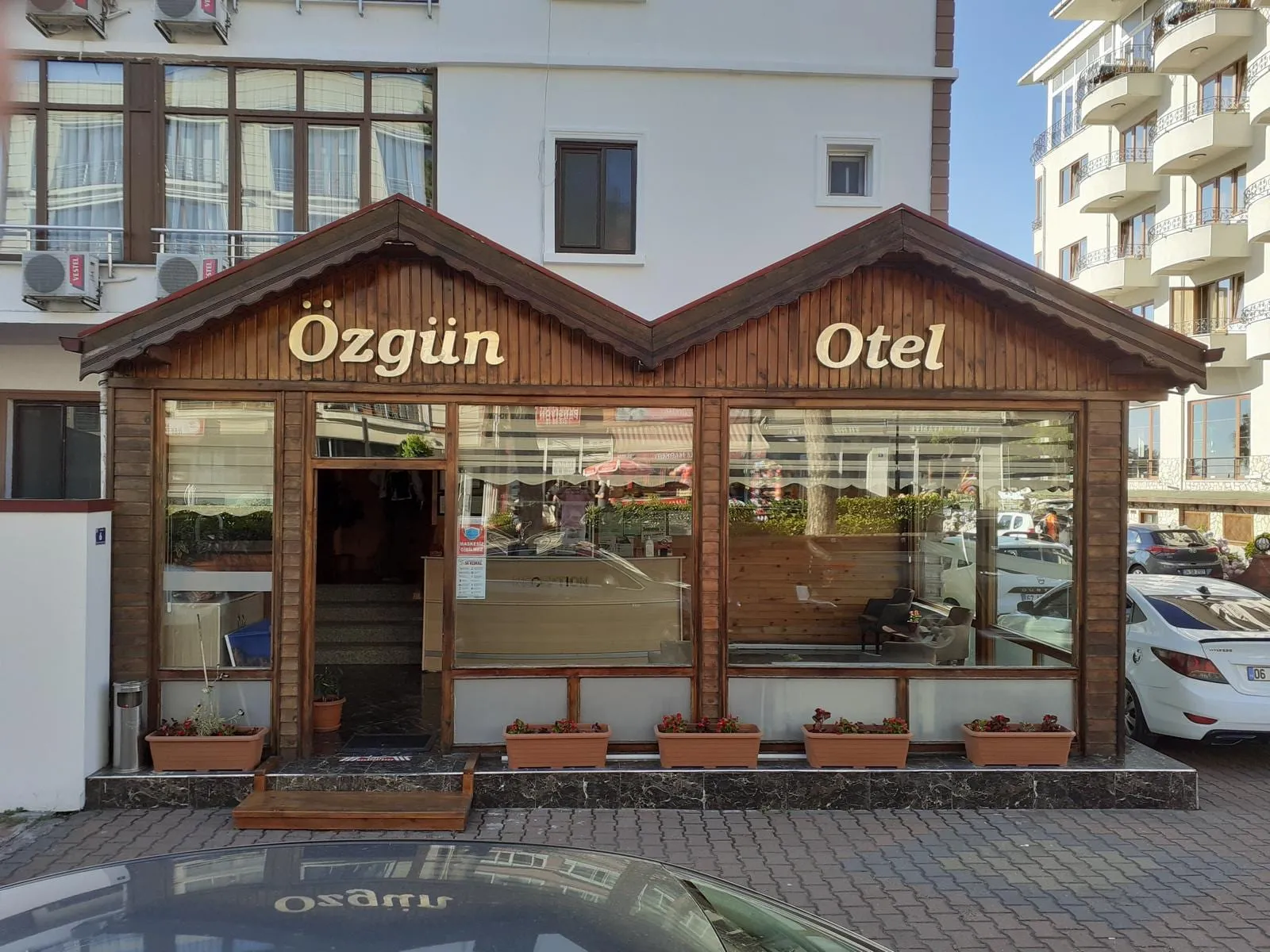 Amasra Özgün Otel'in ahşap cepheli giriş katı ve 'Özgün Otel' tabelası