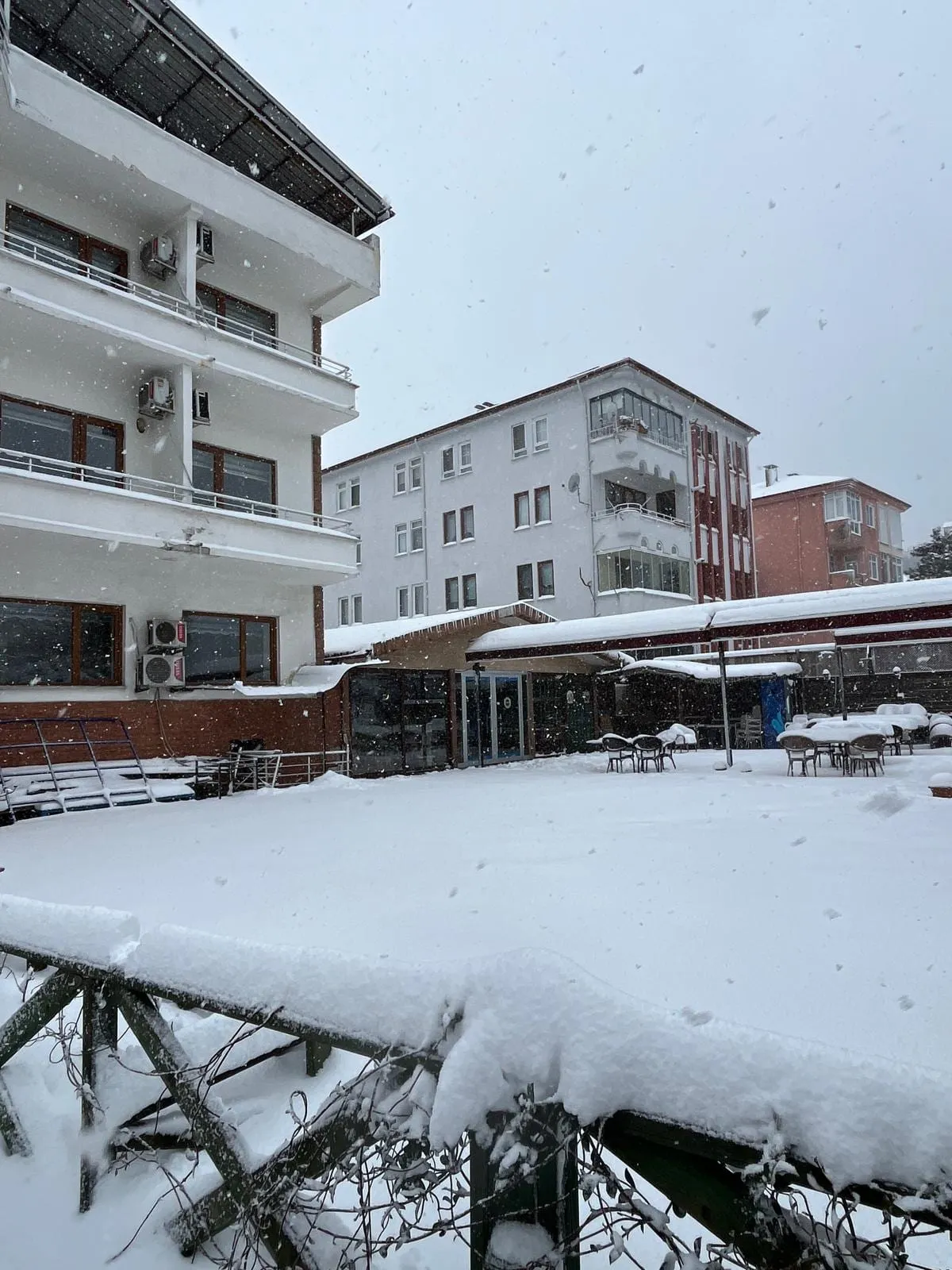 Kar altında otelin bahçesi ve üzeri kapalı teras oturma alanı